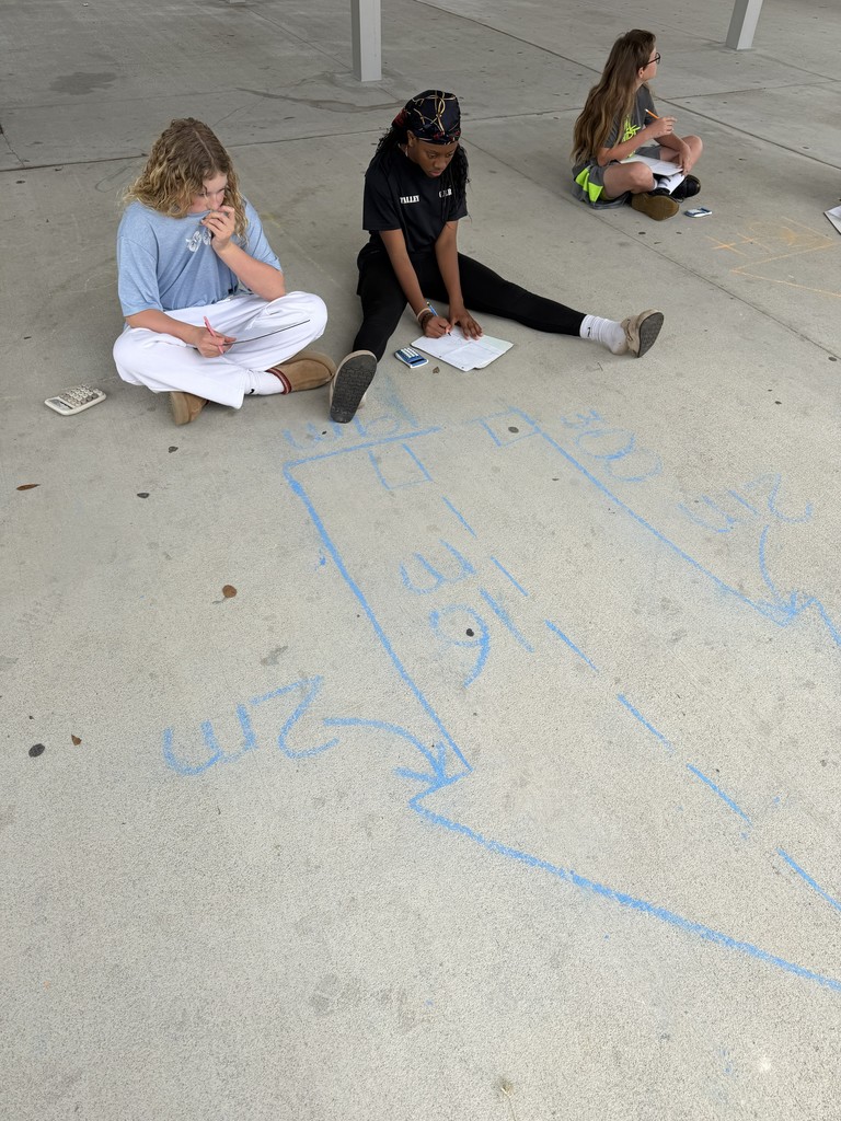 Students working math problems on the concrete.