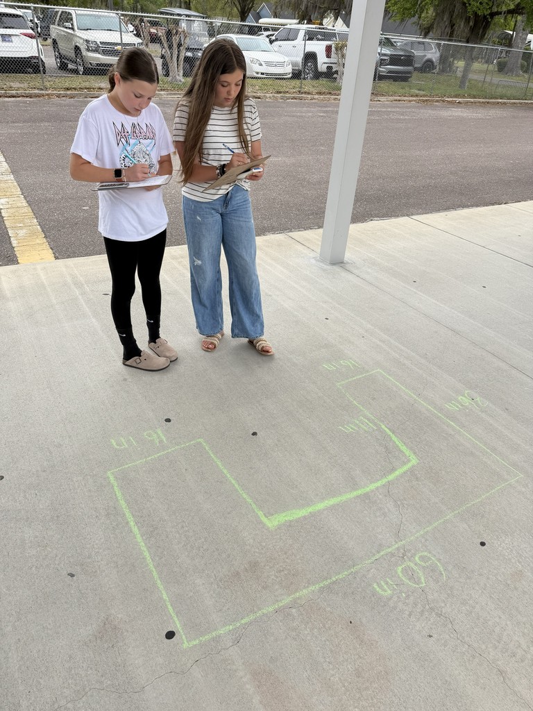 Students working math problems on the concrete.
