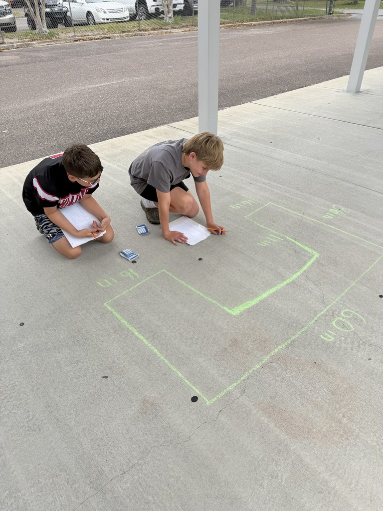 Students working math problems on the concrete.