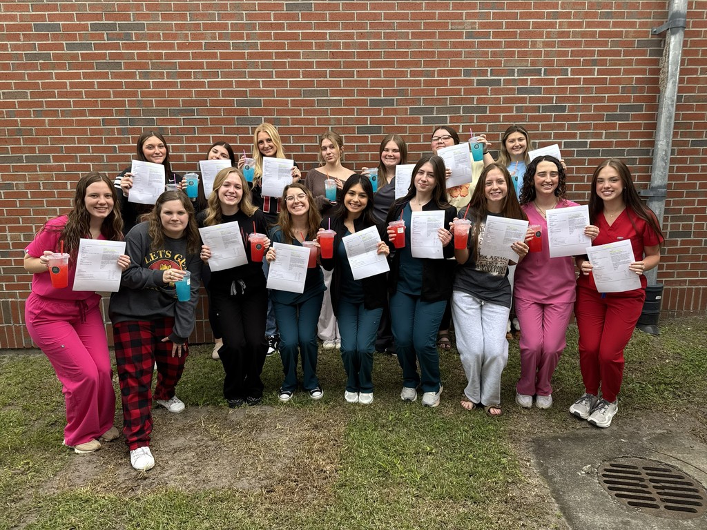 CNA students posing with certificates and lemonade.