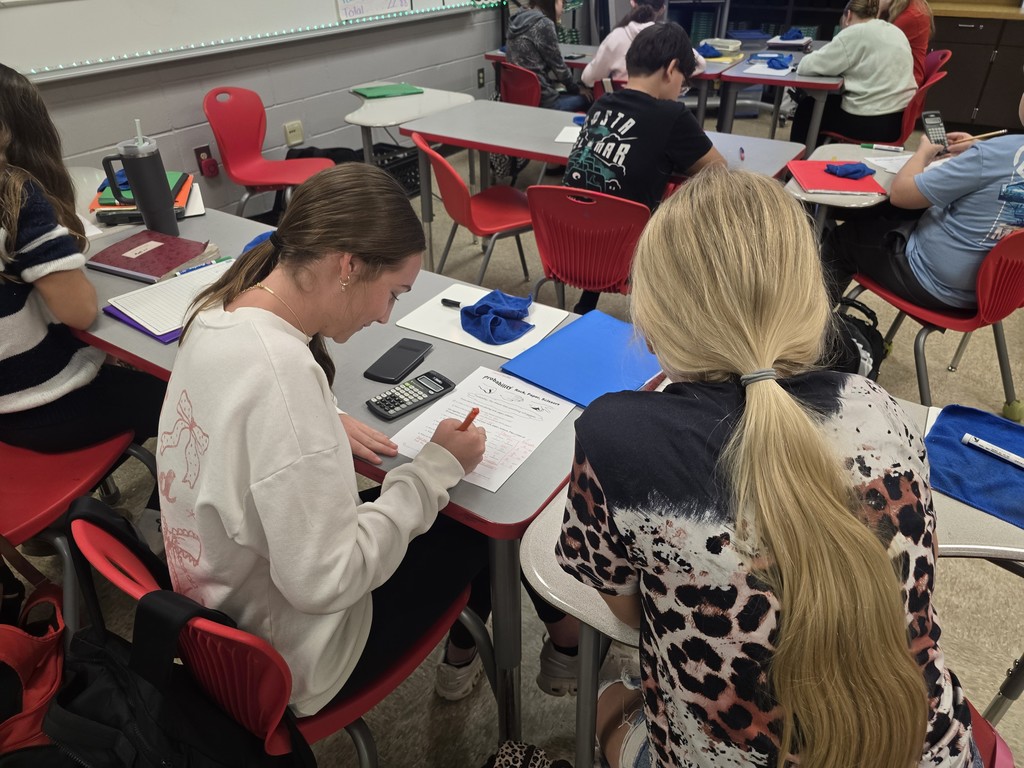 Students at desk working math calculations.