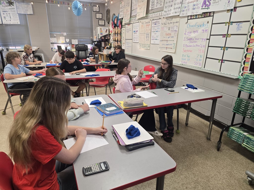 Students at desk working math calculations.