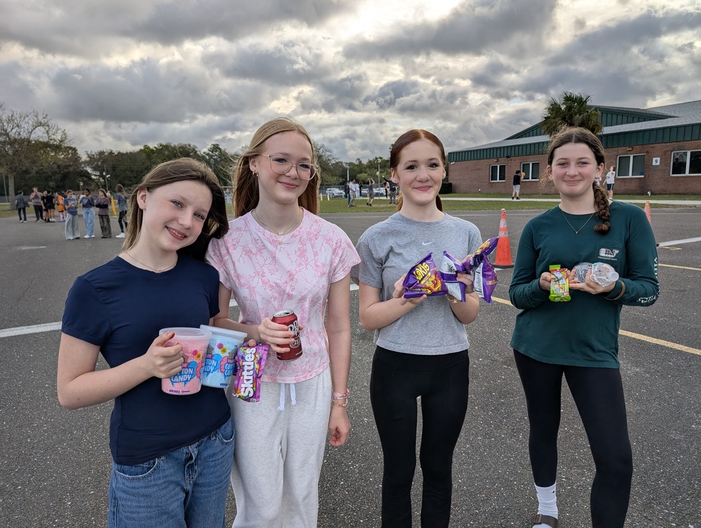 Four students pose for a smiling picture with the treats they bought at Yulee Middle School's infraction free day.