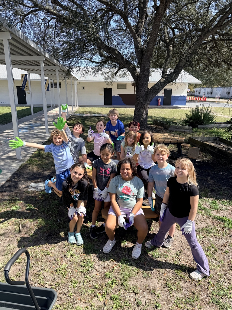 smiling and wearing gardening gloves.