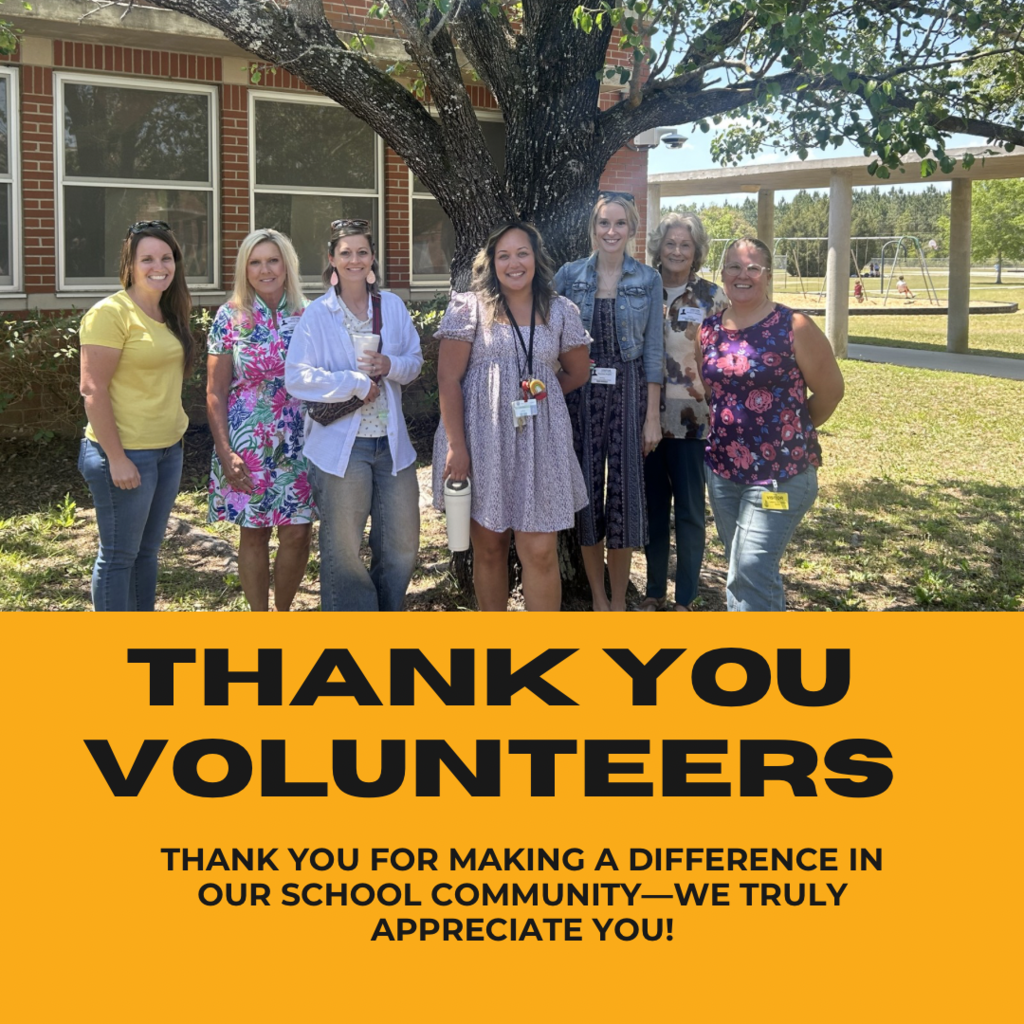 A picture of school volunteers standing under a tree