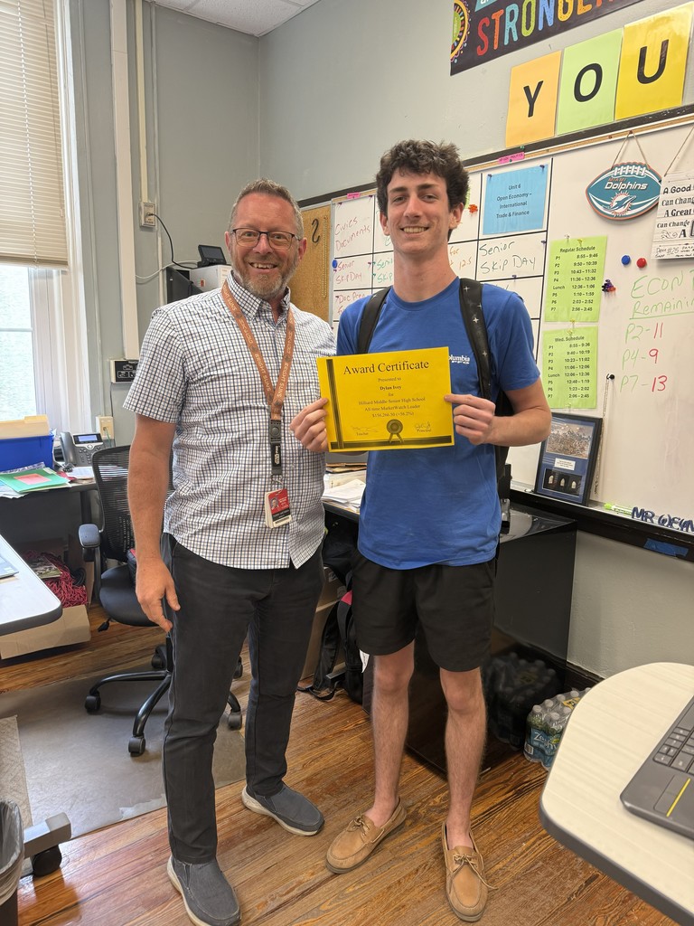 Student holding certificate posing with teacher.