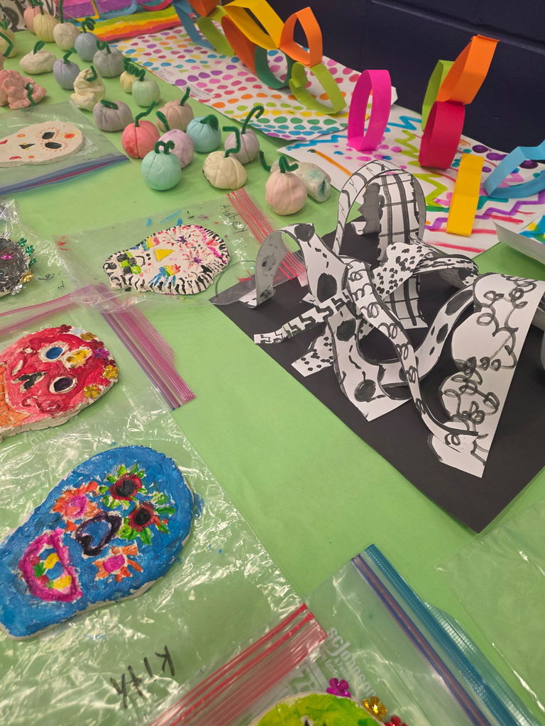 A large, multi-panel mural created by students, featuring a variety of textures and bright patterns.
