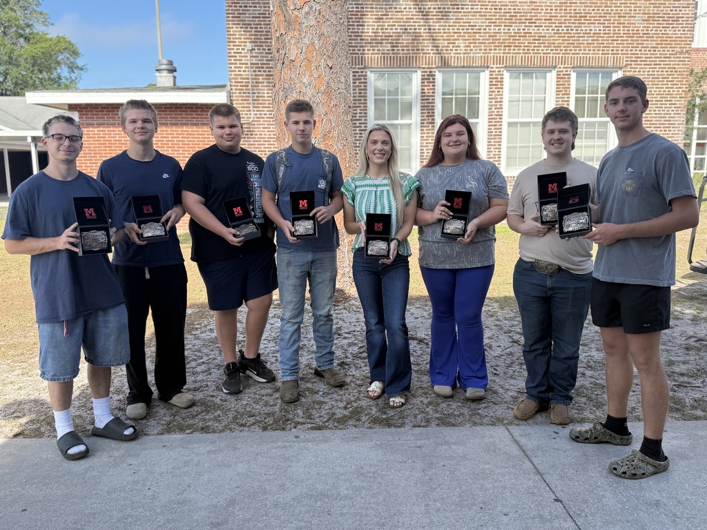 Students hold FFA belt buckles
