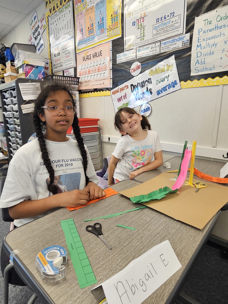 A student focuses intently on assembling a complex structure during a hands-on STEM challenge.