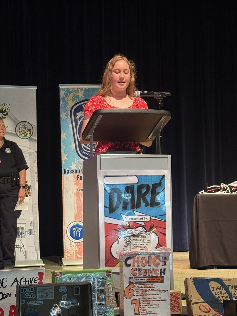 A student standing at the podium, reading their D.A.R.E. essay or commitment pledge to the audience during the graduation ceremony.