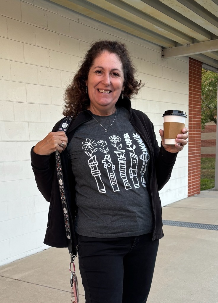 Ms. Campbell holding her coffee cup and showing off her Starwars lightsaber flower planter t-shirt.