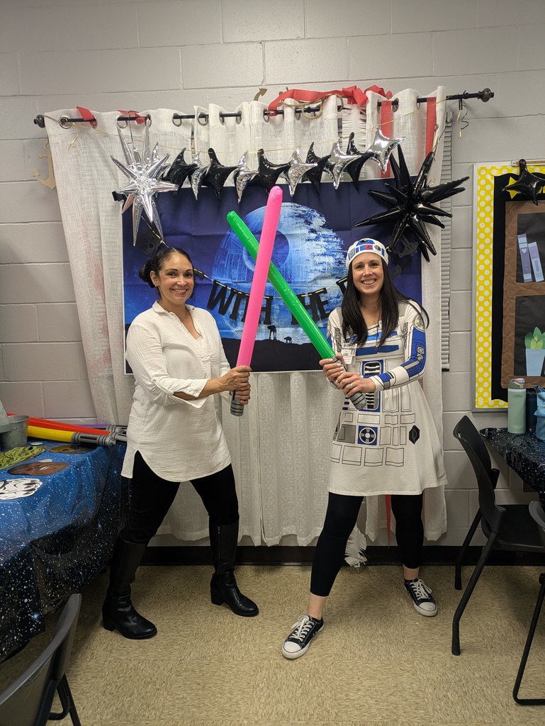 Dr. Weber and Miss bowling posing in front of the death Star dressed up as R2D2 and a Jedi holding pink and green lightsabers.