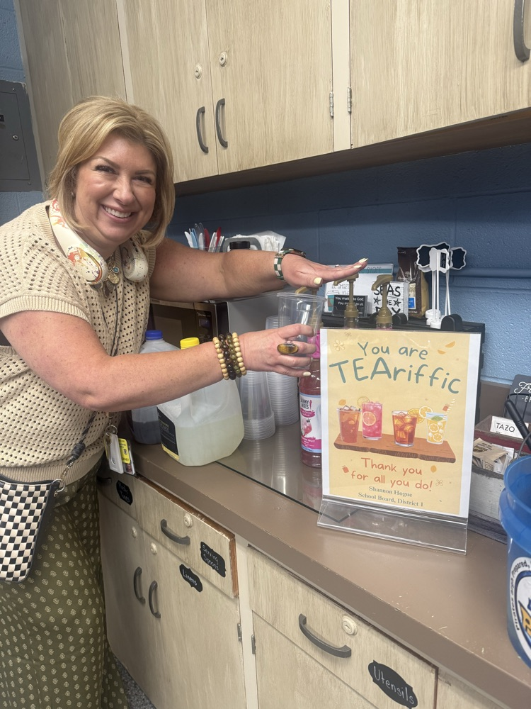 a smiling woman is making herself a flavored lemonade 