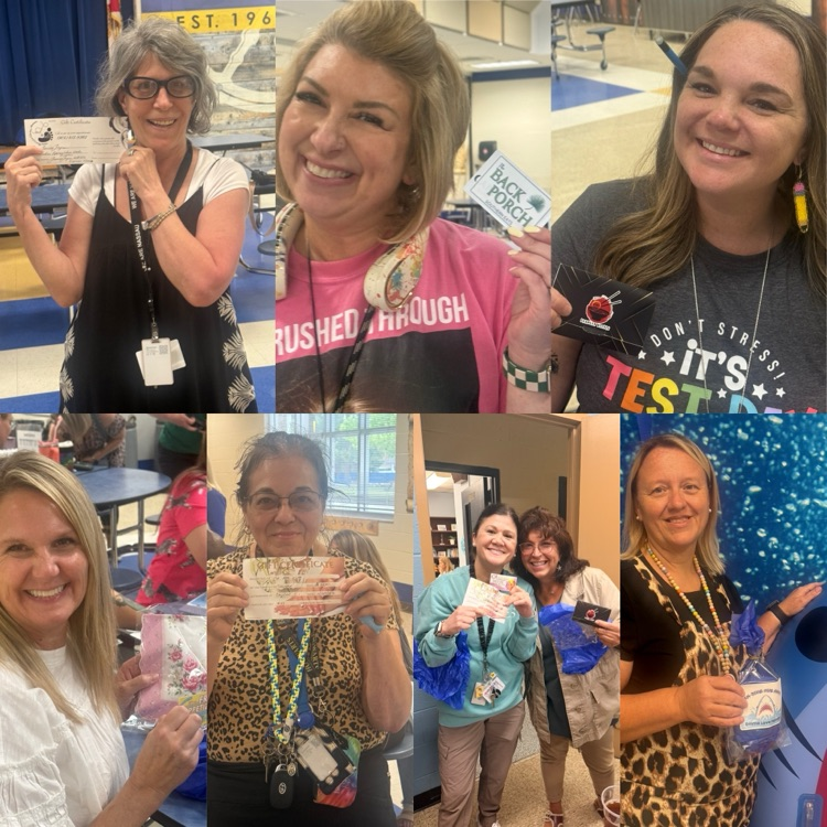several staff members smiling and holding up gift cards form local businesses 