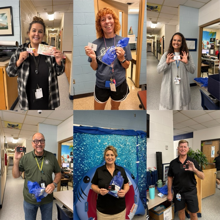 staff members smiling and holding up gift cards