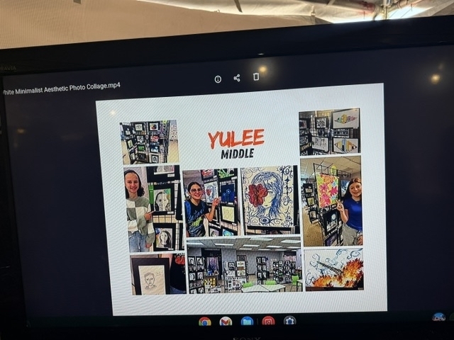 A picture is shown on a screen of Yulee Middle and a collage of photos of artwork and students posing with their artwork in their art classroom.