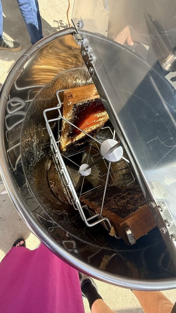 Honeycomb frames spin inside a stainless steel honey extractor during a honey harvesting demonstration at Hilliard Middle-Senior High School.