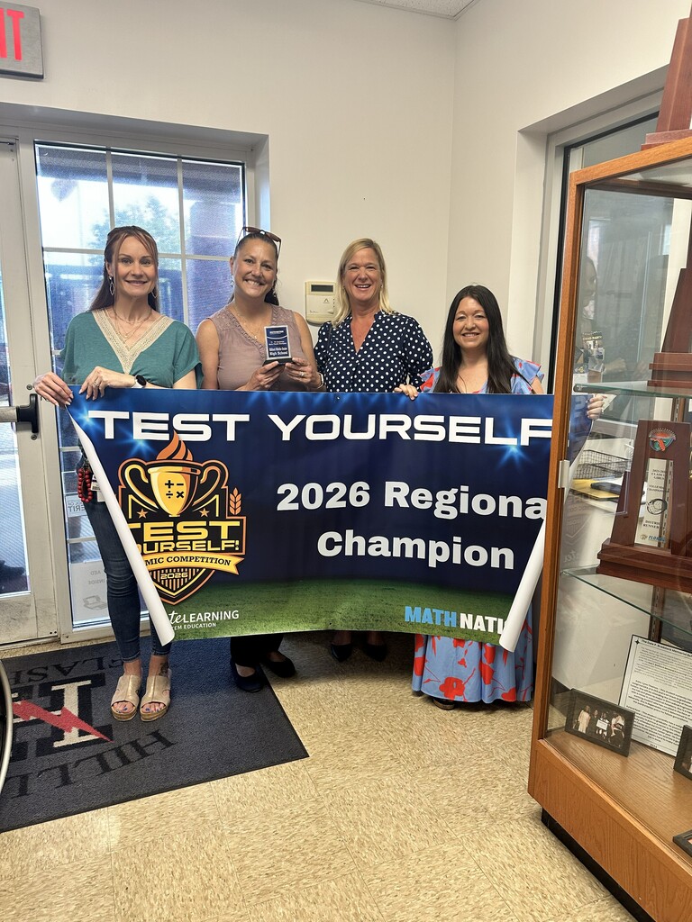 Math Teacher posing with 2026 Regional Champion Banner