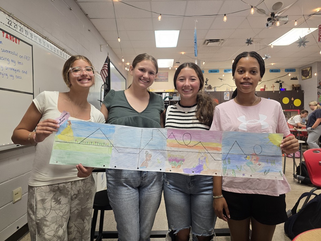 Students posing with roller coaster design.