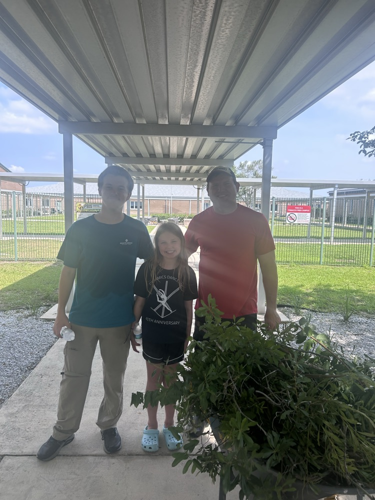 Mr. Miller and his two children outside during campus cleanup