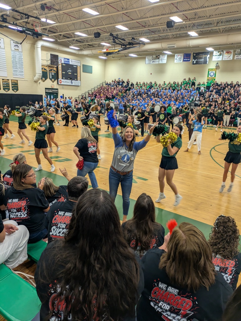 A Southside Elementary staff member enthusiastically cheers with blue pom-poms during the Nassau County Schools Convocation as performers entertain a packed gymnasium filled with educators from across the district.