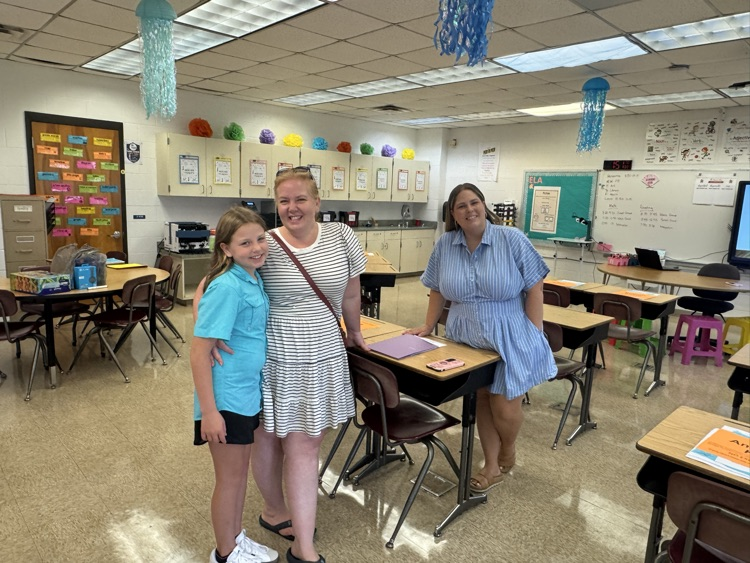 Mrs. Steiger smiles with a student and family during a back-to-school meet-and-greet in her classroom. 