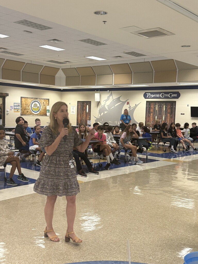 Ms. Hawkins presenting information to students at the back to school pep rally.