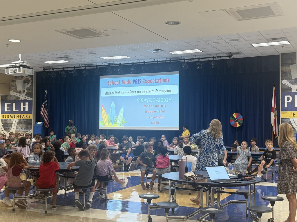 Students and teachers at a back to school pep rally in the cafeteria.