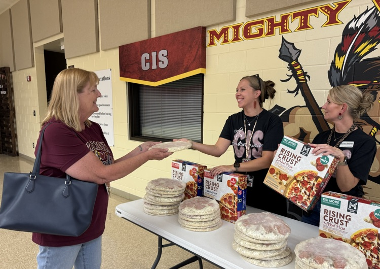 staff handing out pizzas 