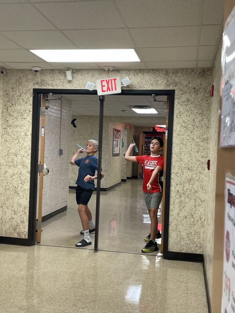 Students throwing paper airplane