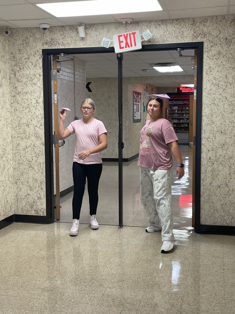 Students throwing paper airplane