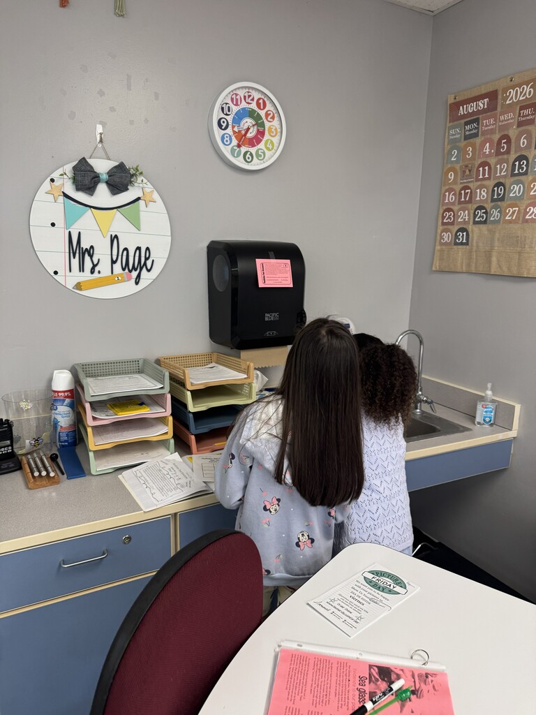2 students in a classroom working on a "scoot" activity.