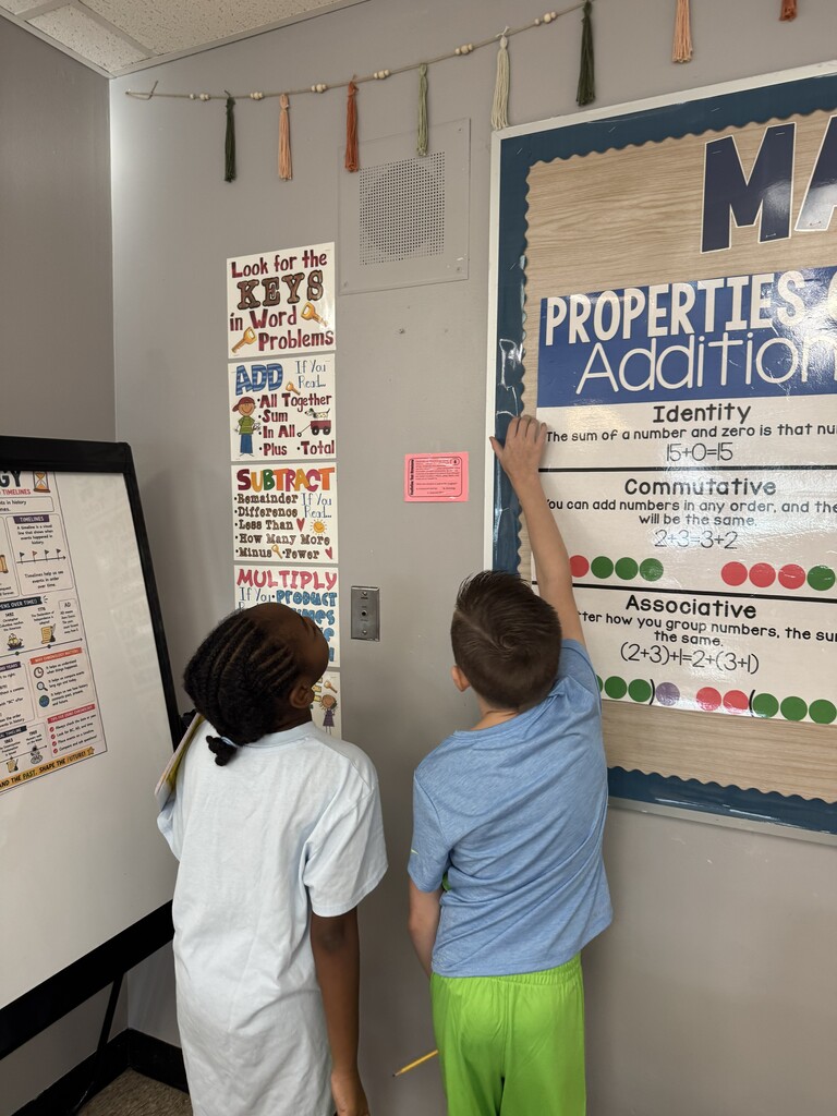 2 students in a classroom working on a "scoot" activity