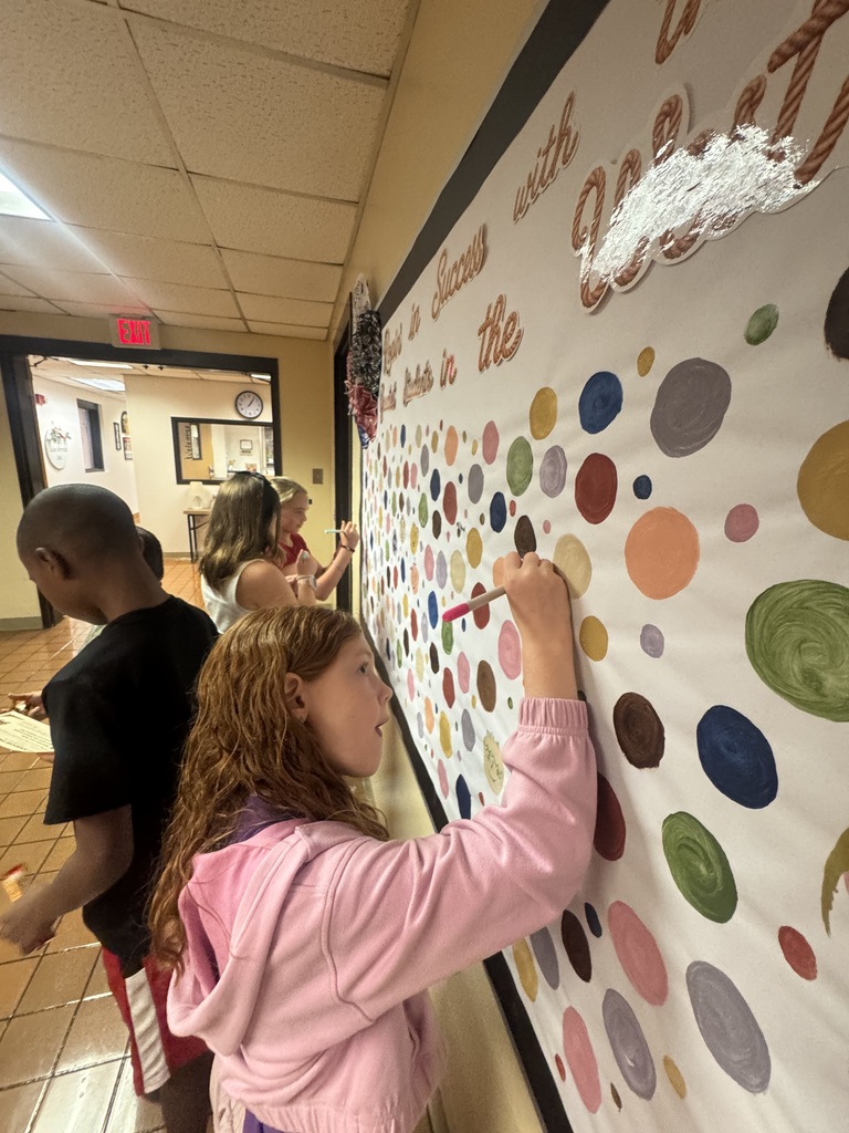 Students make their mark on the on the wall of Success using color markers. These dot artworks will be display all year.