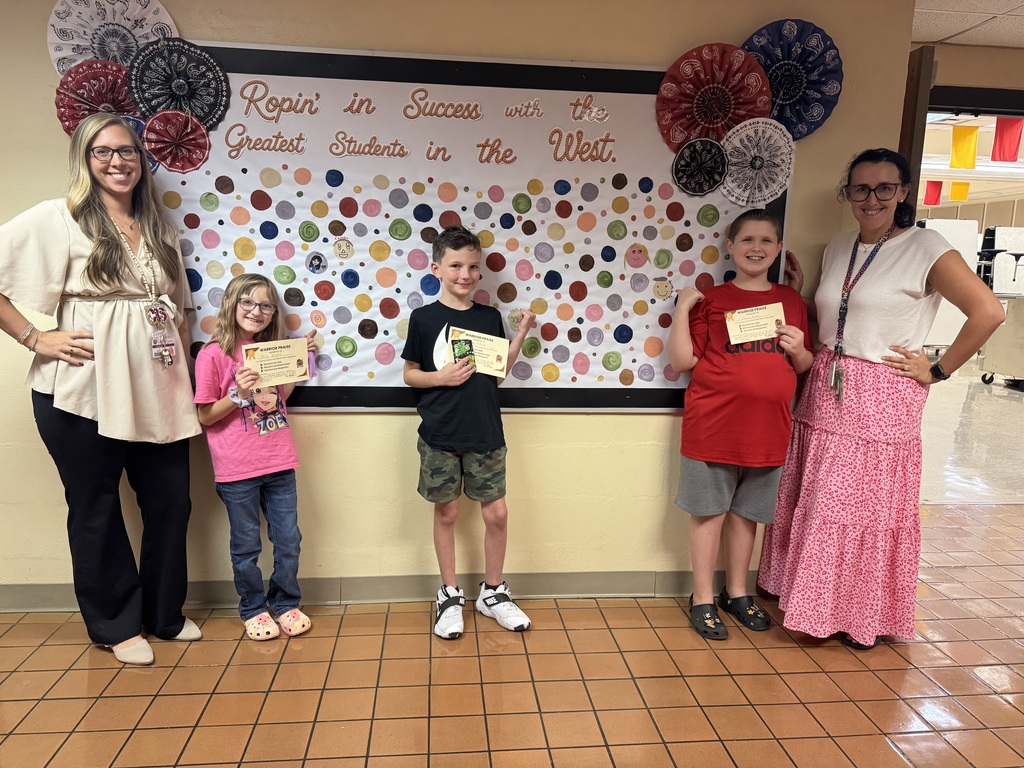 Students proudly point to their dots representing our school-wide expectations: Be Respectful, Be Responsible, and Be Safe. The students smile as they show their commitment to making positive choices at school.