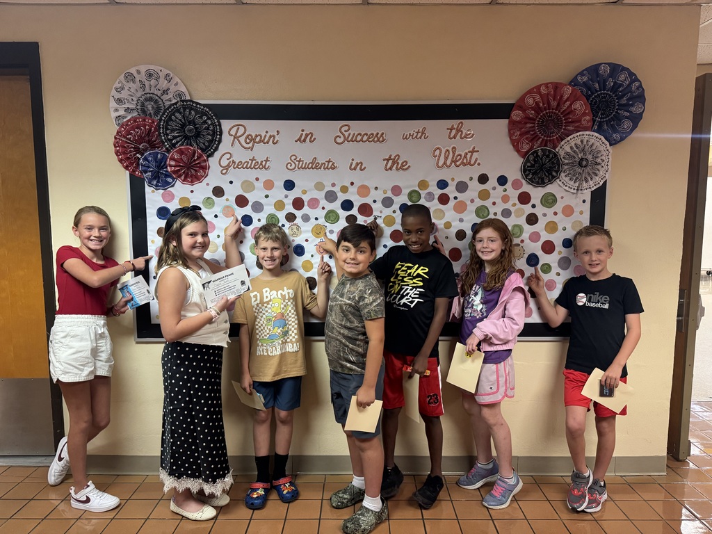 Students proudly point to their dots representing our school-wide expectations: Be Respectful, Be Responsible, and Be Safe. The students smile as they show their commitment to making positive choices at school.