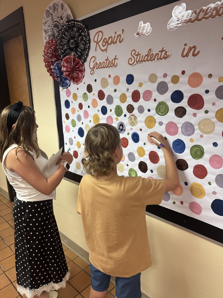 Students make their mark on the on the wall of Success using color markers. These dot artworks will be display all year.