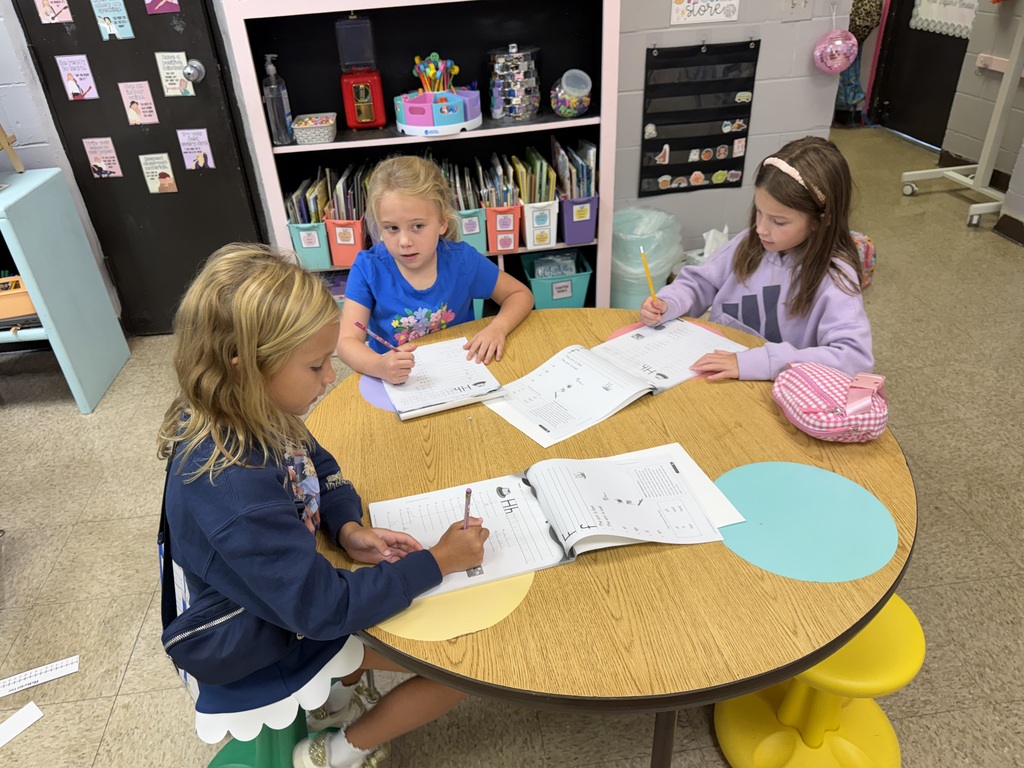 three students working together at a round table
