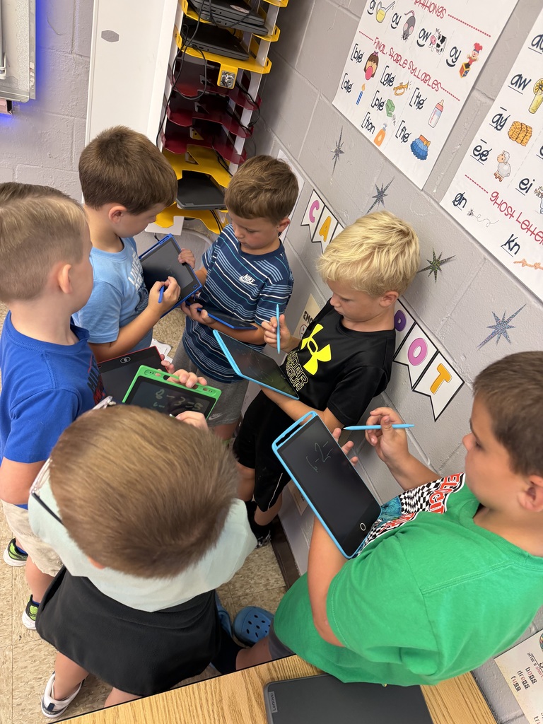 a group of students standing in a circle with writing tablets