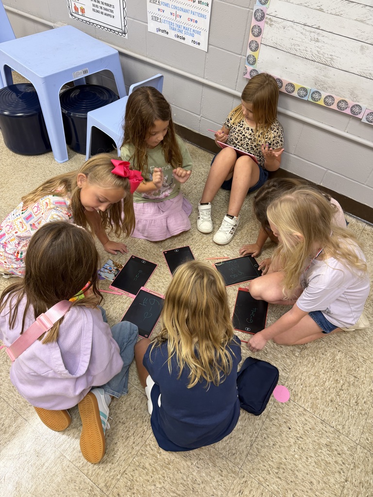 a group of students sitting in a circle on the floor