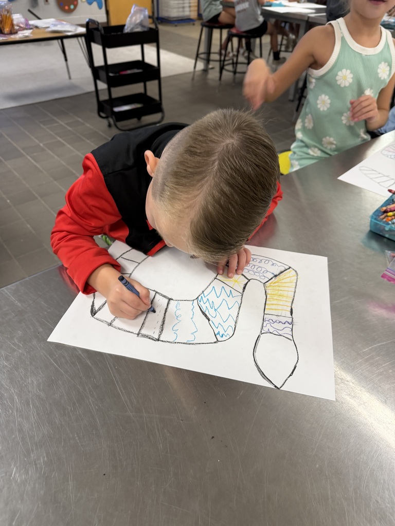 student drawing a variety of zigzag and curved lines in the form of a snake