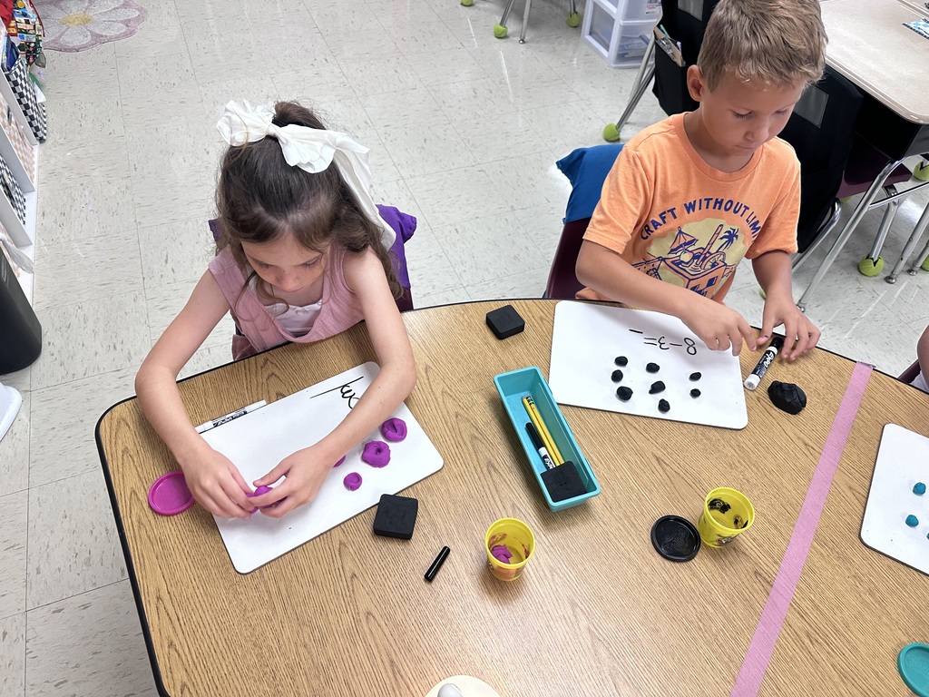 Students use Play-Doh and dry-erase boards during a hands-on math activity.