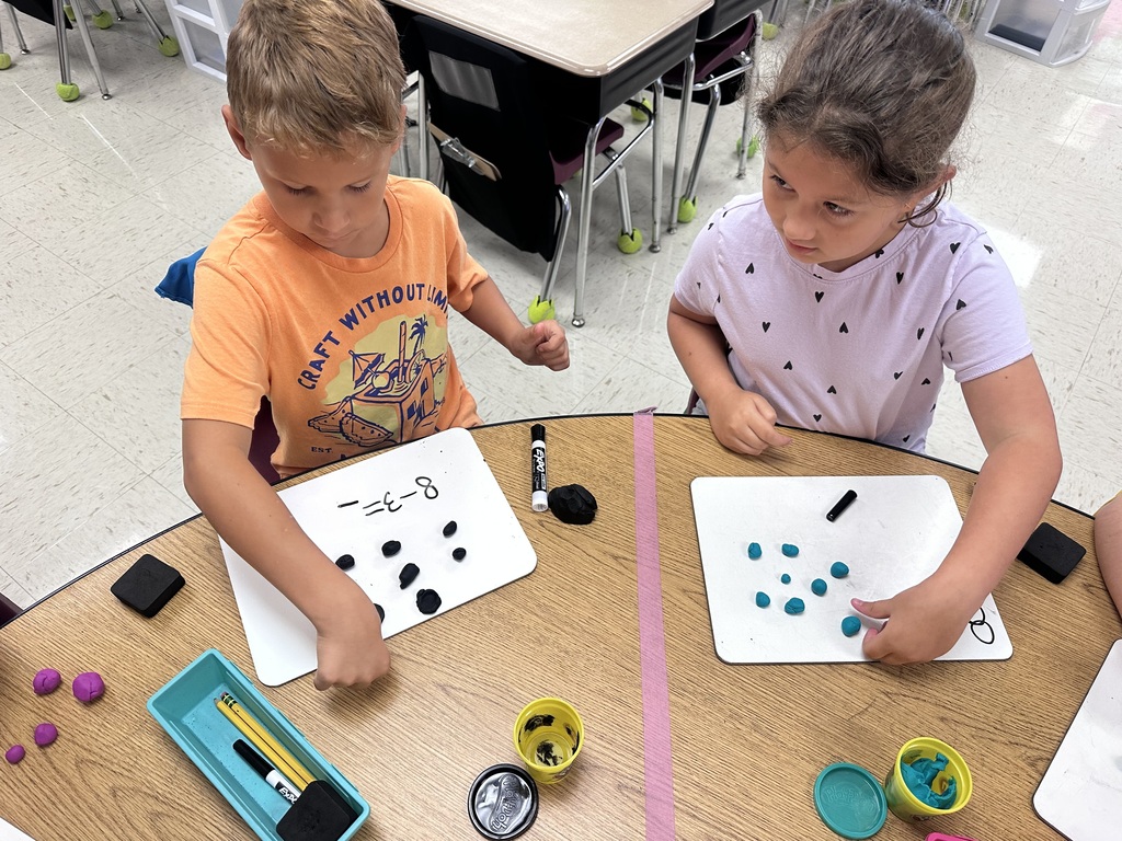 Students use Play-Doh and dry-erase boards during a hands-on math activity.