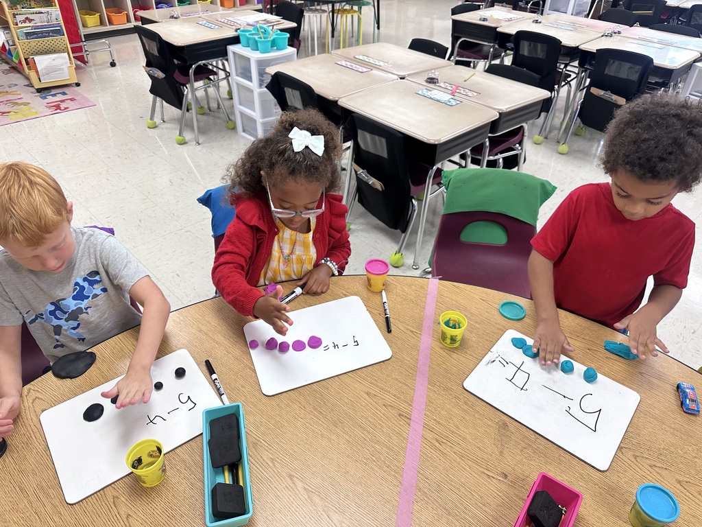 Students use Play-Doh and dry-erase boards during a hands-on math activity.