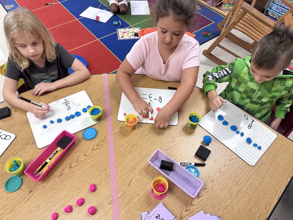 Students use Play-Doh and dry-erase boards during a hands-on math activity.