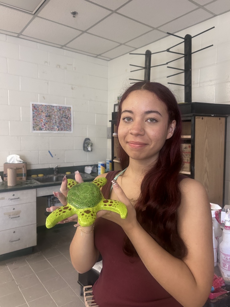 Ceramics student with their work