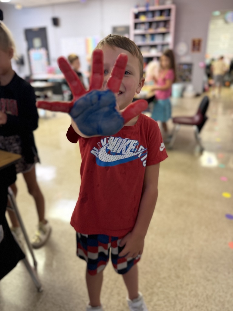 a boy holding up a red and blue painted hand