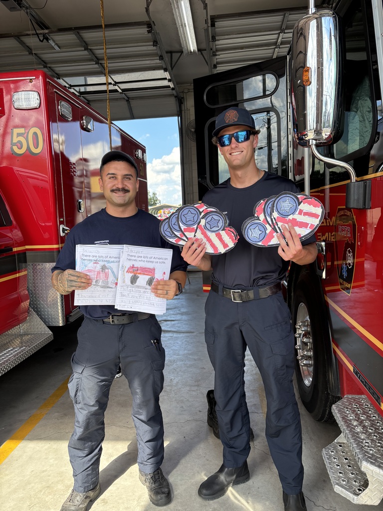 two firefighters holding up crafts for 9-11