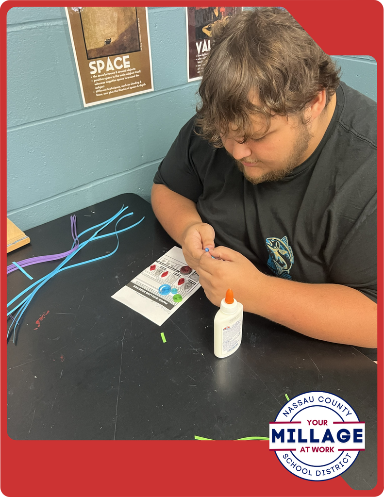 Students are learning to roll, shape, and arrange thin strips of paper into intricate designs, turning simple materials into beautiful works of art.