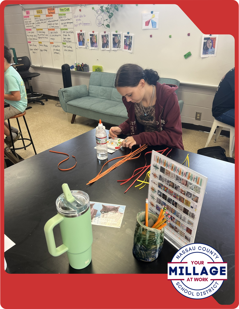 Students are learning to roll, shape, and arrange thin strips of paper into intricate designs, turning simple materials into beautiful works of art.